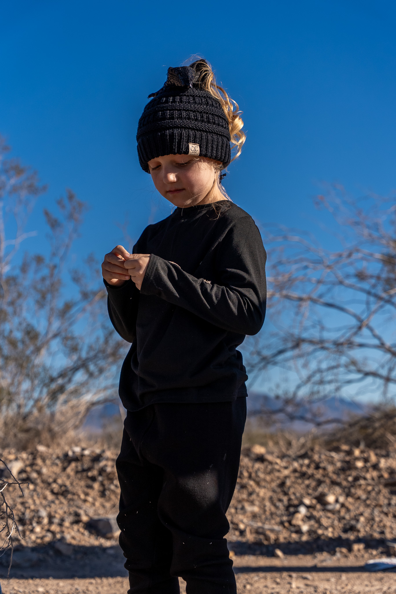 Young girl standing in the desert, beanie hat